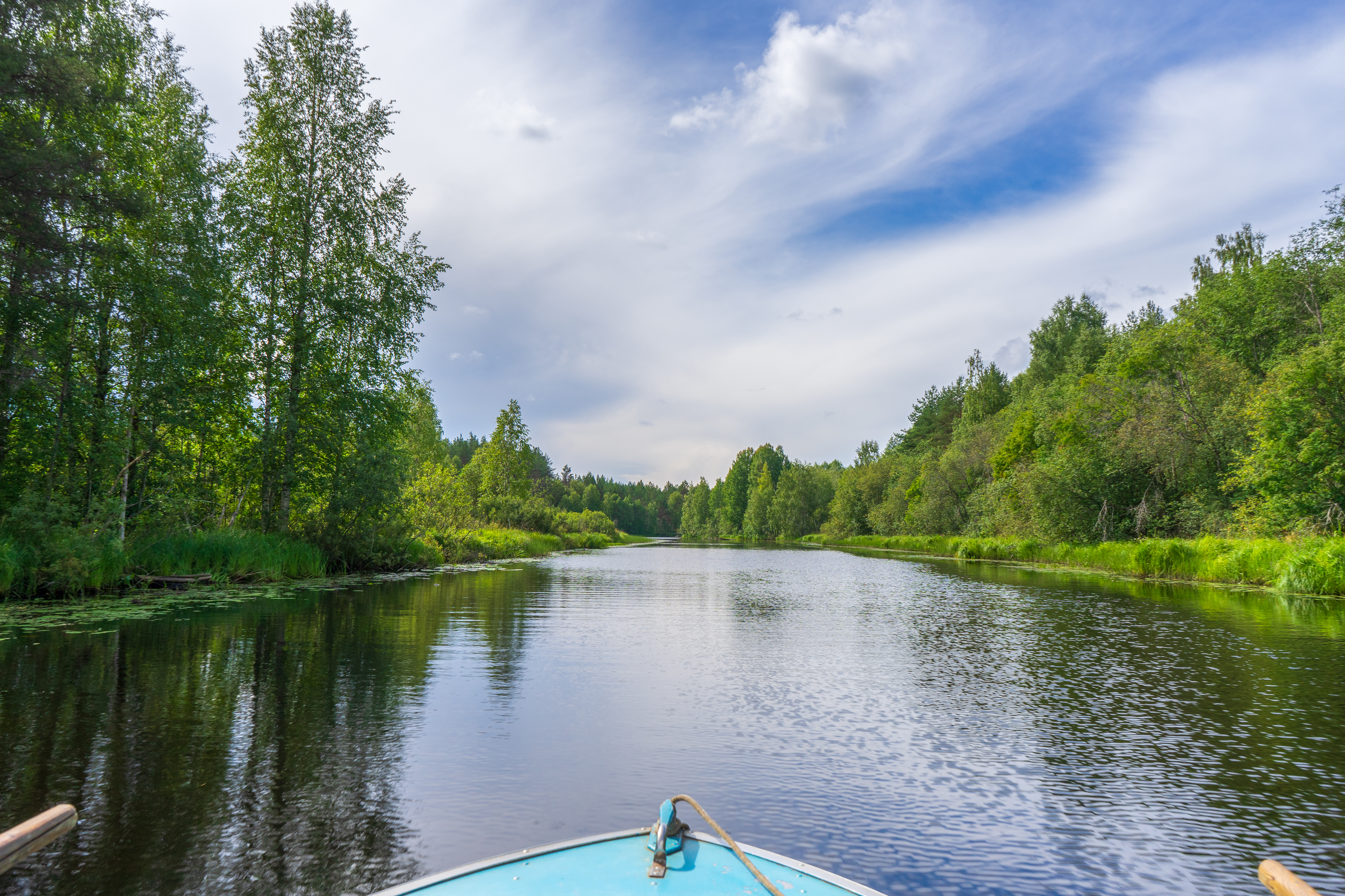 Picturesque summer landscape with northern river and forest in summer cloudy day. Travelling and discovering distant places of Earth. Point of view from floating boat. Chernaya river, Karelia, Russia